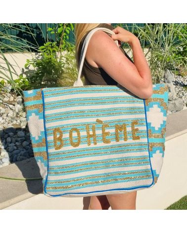 Femme en extérieur avec un sac de plage turquoise perlé BOHÈME, style bohème chic et estival