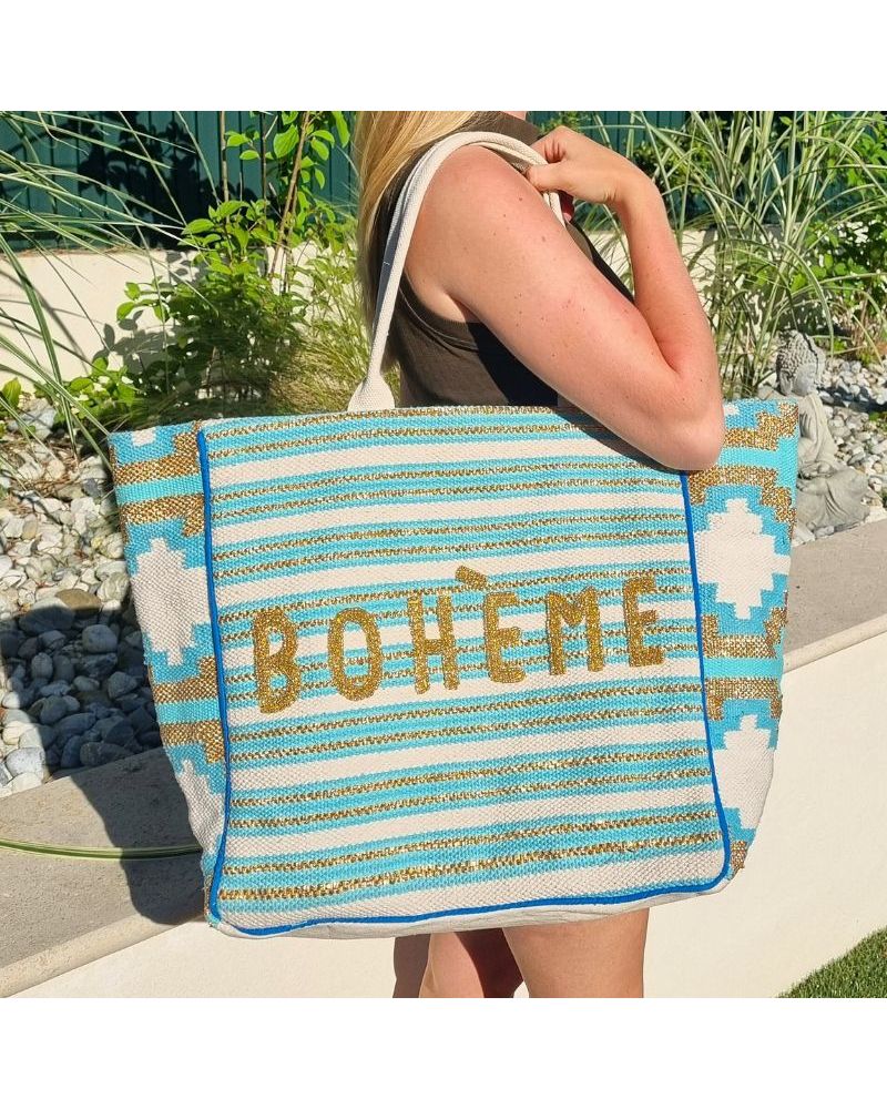 Femme en extérieur avec un sac de plage turquoise perlé BOHÈME, style bohème chic et estival