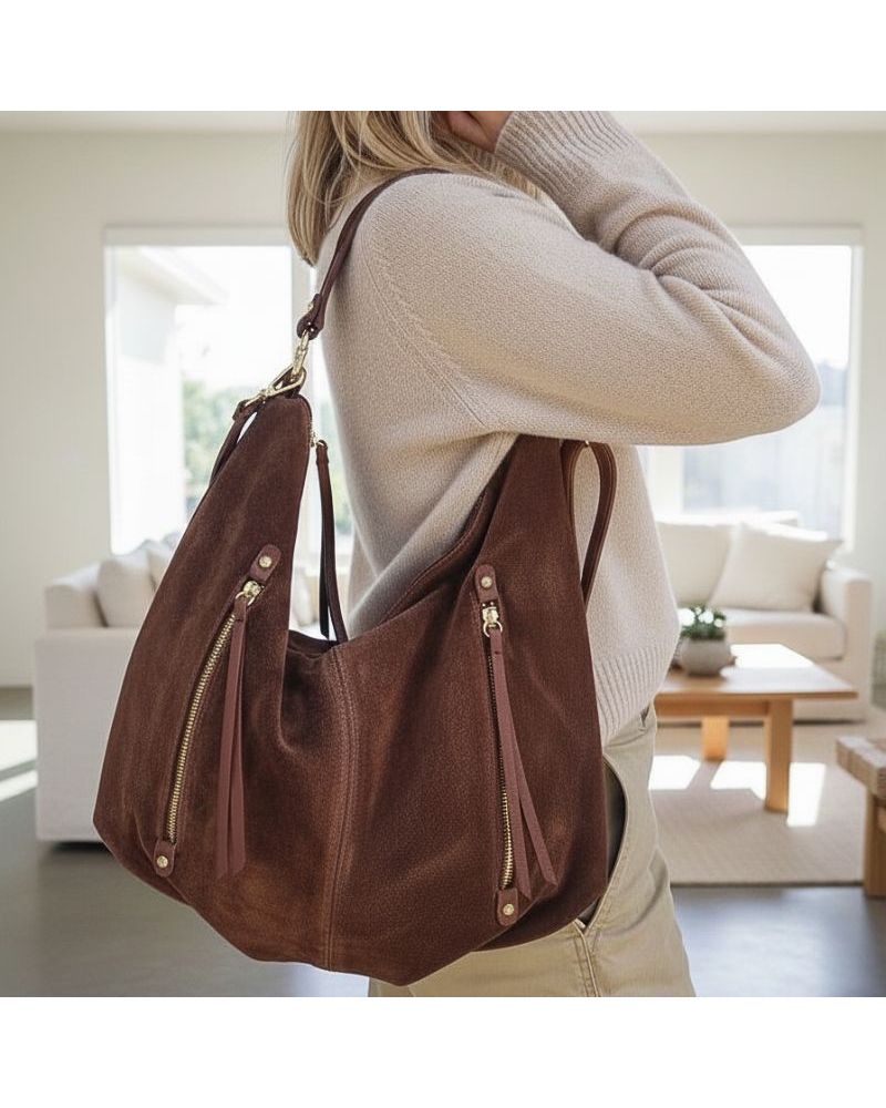 Sac en daim marron porté à l'épaule, style bohème chic avec poches zippées