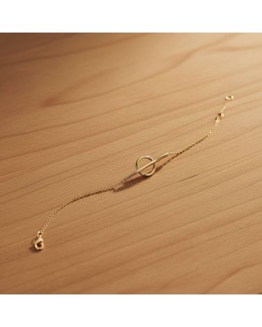 Bracelet minimaliste en plaqué or 18 kt posé sur une surface en bois
