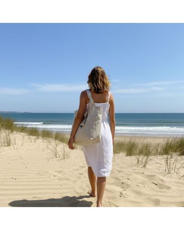 Sac de plage rayé camel et blanc Marinella en coton grand format avec fermeture zippée sur la plage face à l’océan