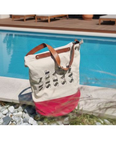 Sac de plage Chloé en toile écru et rouge posé sur une terrasse de piscine moderne, ambiance villa de vacances à Hossegor