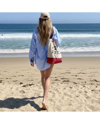 Sac de plage en toile recyclée et anses cuir porté par une femme qui marche sur la plage de Seignosse