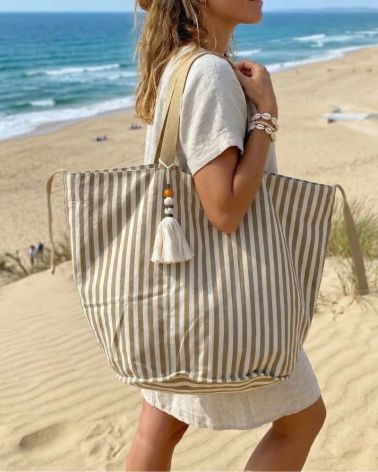 grand sac de plage en toile rayé écru et kaki clair porté épaule