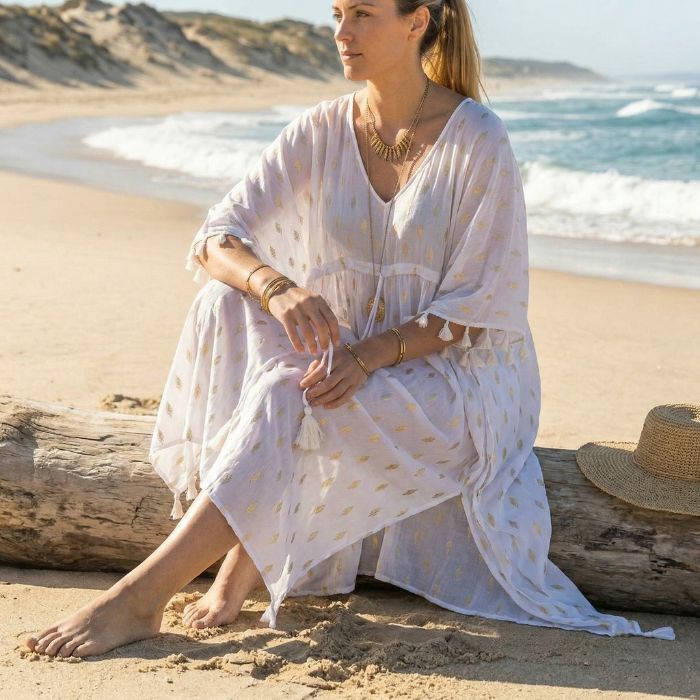 femme assise sur la plage face à l’océan moment de calme et de détente