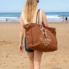 Femme portant à l'épaule le grand sac de plage XXL Sel de Mer marron pécan, cabas en toile recyclée Zosha Collection