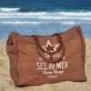 Grand sac de plage marron pécan Sel de Mer posé sur le sable d'une plage des Landes, montrant sa capacité XXL pour tout emporter à la plage