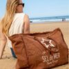 Grand sac de plage marron pécan Sel de Mer posé sur le sable fin, montrant sa capacité XXL pour tout emporter à la plage