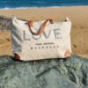 sac de plage xxl brodé love en toile upcyclée posé sur la plage de hossegor sac de plage XXL brodé LOVE en toile upcyclée posé sur la plage de Hossegor