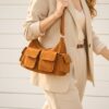 Sac en cuir suède multipoche Sienna porté à l’épaule, style chic et décontracté couleur camel