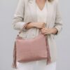 Femme style effortless chic portant le sac Lucile rose poudré à franges en cuir suédé