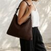 Sac pochette rectangulaire en cuir marron tressé main porté épaule